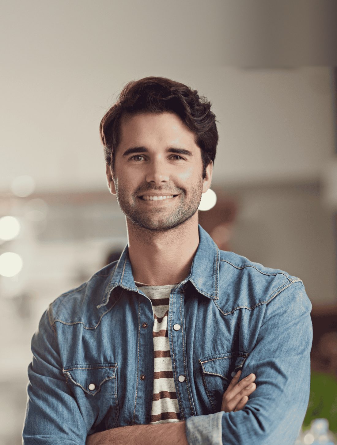 A smiling man with a full head of dark hair, arms crossed
